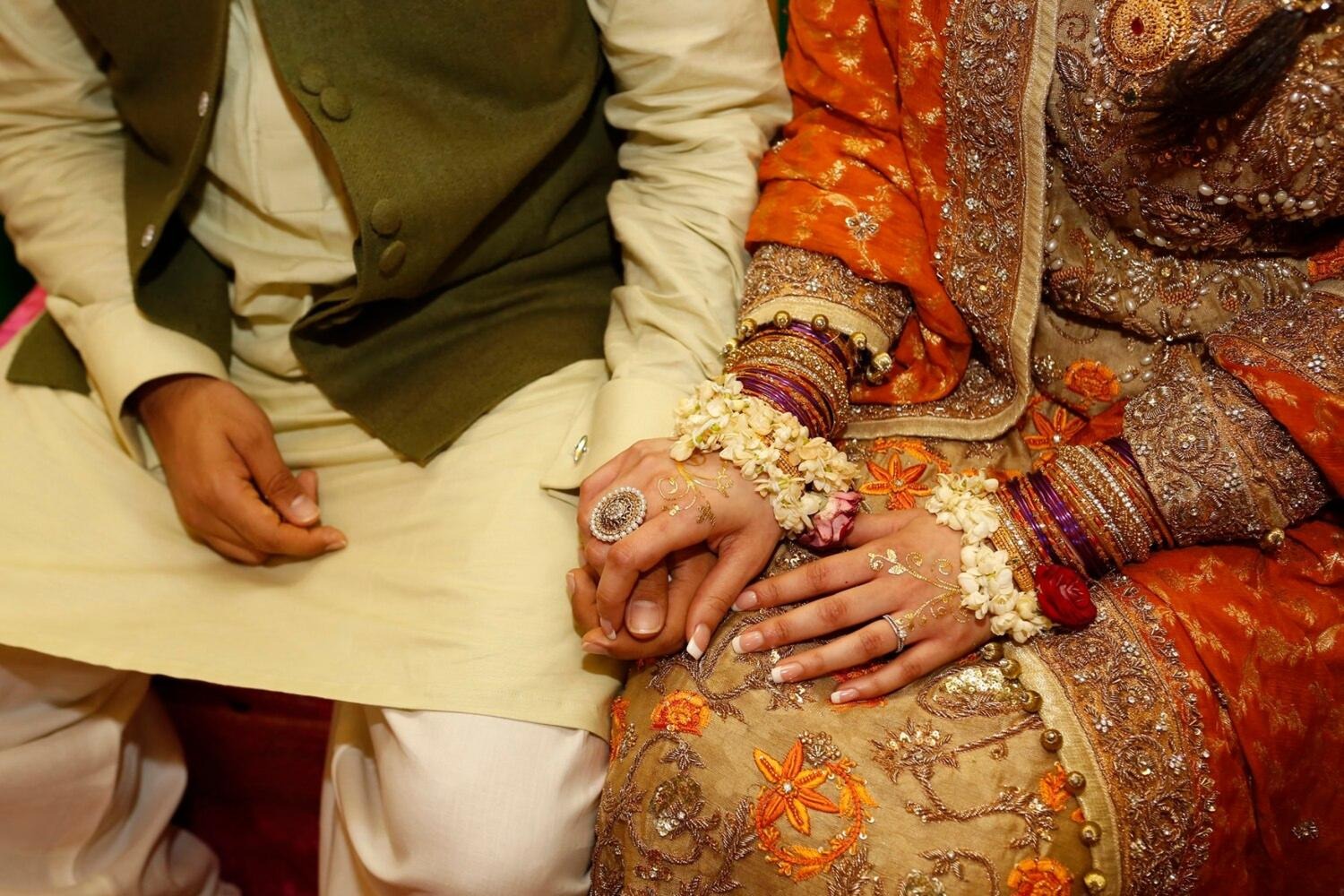 A newlywed couple holding hands